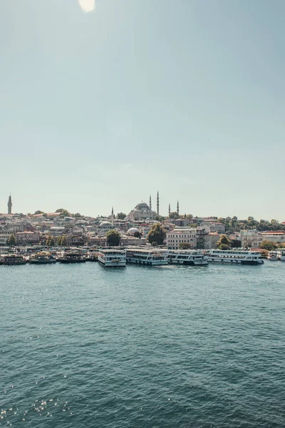 Barcos amarrados en la orilla del mar, y vista de la ciudad desde el estrecho del Bósforo, Estambul, Turquía - foto de stock