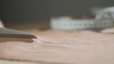 Parlak sarı kumaşı makasla kes, yakın plan..