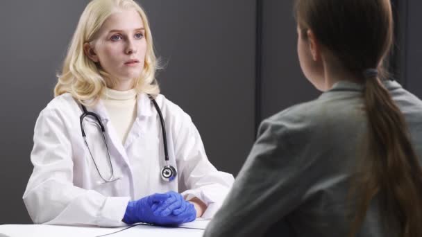 Dokter memeriksa catatan medis. Dokter wanita bermantel putih di tempat kerja — Stok Video