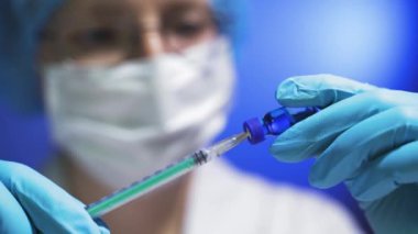 Doktorlar ellerinde şırınga ve aşı ile tüp tutuyorlar..