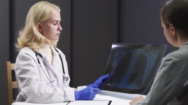 女医生解释说，在医院的检查室里，X光胸腔会导致电脑笔记本电脑的出现. — 图库视频影像
