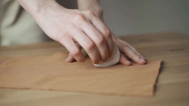 Close-up: vrouwelijke handen van een naaister. Ze brengt het patroon aan op de felgele stof op de tafel.. — Stockvideo