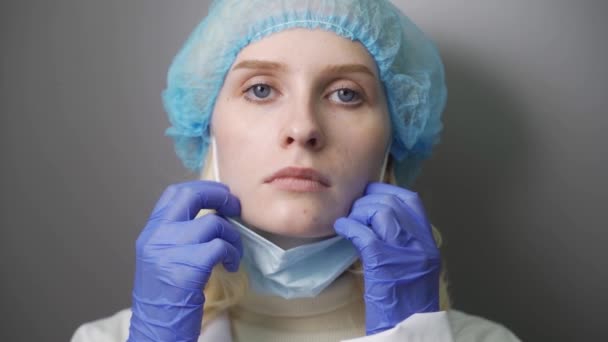 Жінка наносить хірургічну маску для захисту від коронавірусу SARS-CoV-2 . — стокове відео
