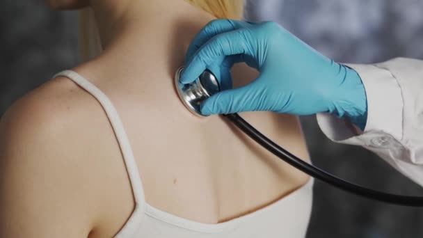 Medico femminile che utilizza il suo stetoscopio per ascoltare i suoi pazienti polmone femminile mentre respira. — Video Stock