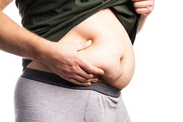 A man in a t-shirt and underpants shows overweight — Stock Photo, Image