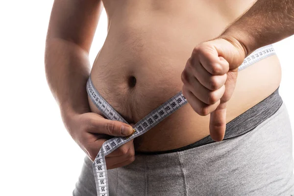 Man showing thumbs down while measuring his waist — Stock Photo, Image
