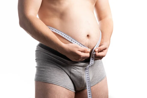 A man in the process of measuring his waist with a centimeter — Stock Photo, Image