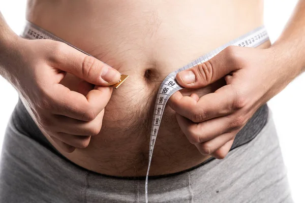 A man in the process of measuring his waist — Stock Photo, Image