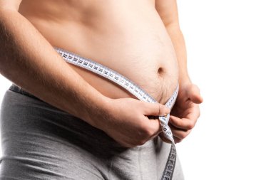 Adam göbeğini mezurayla ölçüyor.