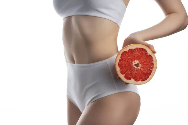 Menina segurando uma toranja de corte no nível da cintura — Fotografia de Stock