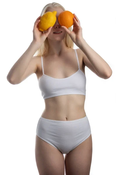 Girl closing her eyes with citrus stands on an isolated background — Stock Photo, Image