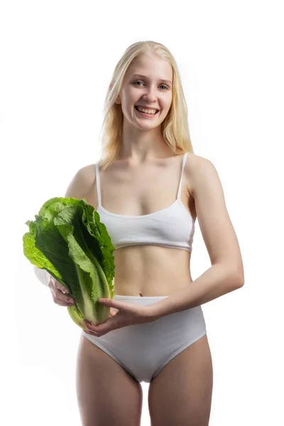 Jovem mulher apto com centímetro em torno de seu pescoço segurando salada fresca em uma mão — Fotografia de Stock