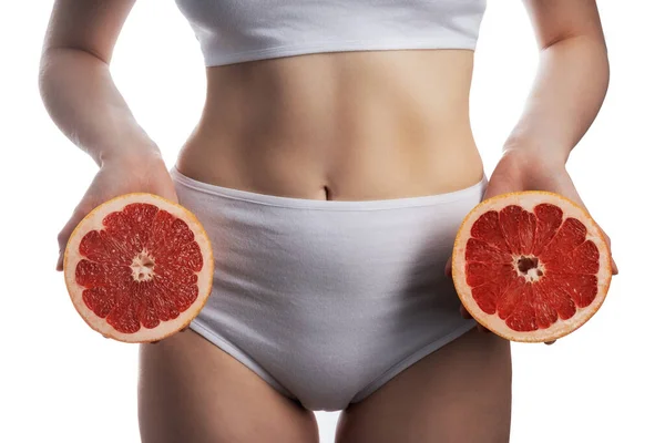 Grapefruit diet. Young woman in fitness clothing, isolated on white background — Stock Photo, Image