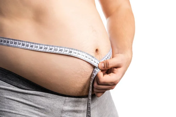 Tlustý muž podívejte se na jeho tělo tuk s měřicí páskou pro bílé pozadí — Stock fotografie