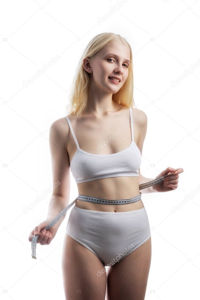 one attractive Caucasian girl in white panties with a centimeter measuring hips and waist on white background