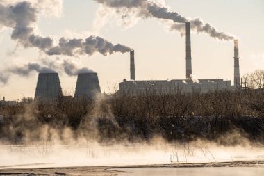 Elektrik santrali gölün yanında gaz çıkarıyor.
