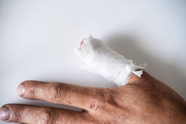 İzole edilmiş arka planda, sargılı parmağı olan kaba erkek eli.