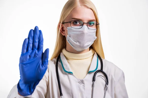 Covid19, coronavirus, healthcare and doctors concept. Serious female doctor in medical mask, with stethoscope and white coat, show stop sign