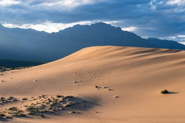 Chara 'lı Sandy tepesi, dağların arka planına karşı.