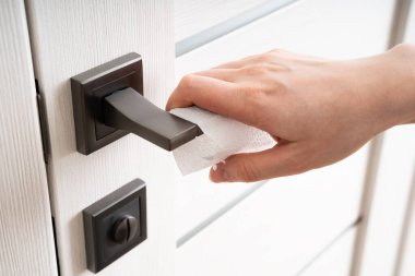 Coronavirus COVID-19 Önleme temizleyici kadın antibakteriyel dezenfekte ile kapı tokmağı temizleme Corona virüsü öldürmek için