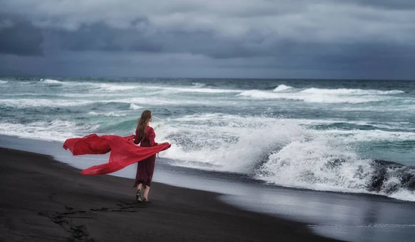 Una ragazza vestita di rosso cammina sulla riva dell'Oceano Pacifico — Foto Stock