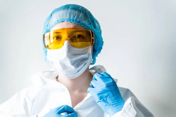 Doktor kadın yüz maskesi takar ve kameraya bakar. Grip, grip, virüs, bademcik iltihabı, akut solunum hastalığı, karantina, salgın konsepti.