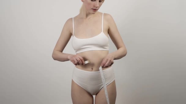 Jeune femme mince mesure la taille. Concept de perte de poids. — Video