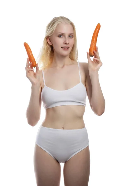 Портрет красивої дівчини зі стиглою морквою, яка посміхається на камеру на білому тлі — стокове фото