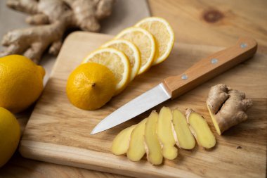 Tahta bir arka planda limonata ve zencefilli bir tabakta limonata arınma malzemesi olarak kullanılıyor.