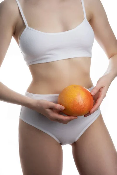 Grapefruit diet. Body part, Young woman in fitness clothing, isolated on white background — Stock Photo, Image