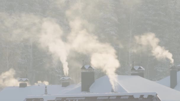 En el frío invierno, el humo sale de la chimenea. — Vídeos de Stock