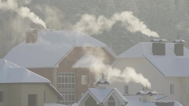 En el frío invierno, el humo sale de la chimenea. — Vídeos de Stock