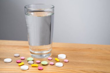 Beyaz zemin üzerinde su ve ilaç kapsülü