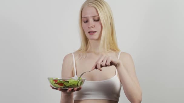 Portret van een lachende vrouw die thuis verse salade eet. — Stockvideo