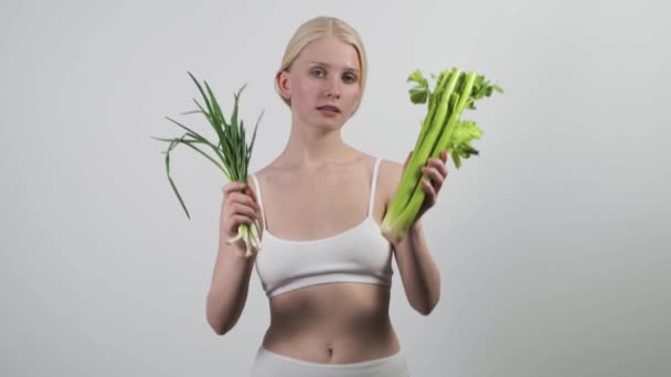 Wanita muda cantik memegang daun hijau, merekomendasikan makanan alami vegan — Stok Video