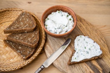 bir parça ekmek üzerinde otlu süzme peynir.