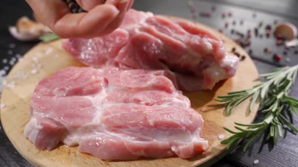 Filete de res crudo en una mesa de madera oscura. Cocinero decora con una ramita de romero — Vídeos de Stock