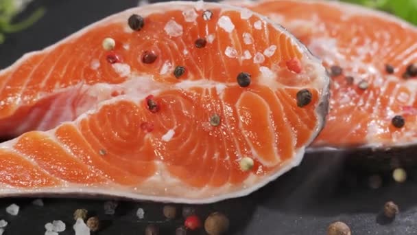 Salmone. Bistecca di pesce rosso di trota cruda con erbe aromatiche e limone e olio d'oliva ruotato su ardesia. — Video Stock