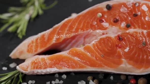 Lachs. Rohe Forelle Rotes Fischsteak mit Kräutern und Zitrone und Olivenöl auf Schiefer. — Stockvideo