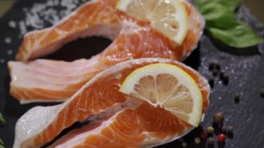 Somon balığı. Çiğ Alabalık Kırmızı Balık Bifteği, şifalı bitkiler, limon ve zeytinyağı. Yavaş çekim 4K UHD video