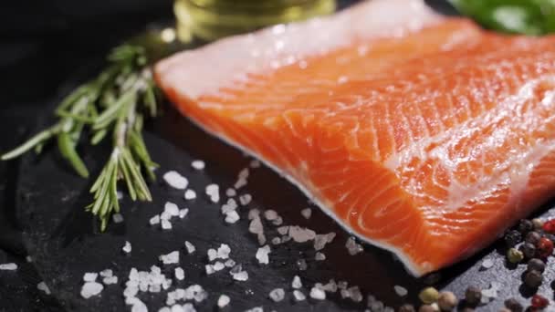 Preparación de filete de salmón. Especias y sal espolvoreadas sobre un trozo de salmón crudo. — Vídeo de stock