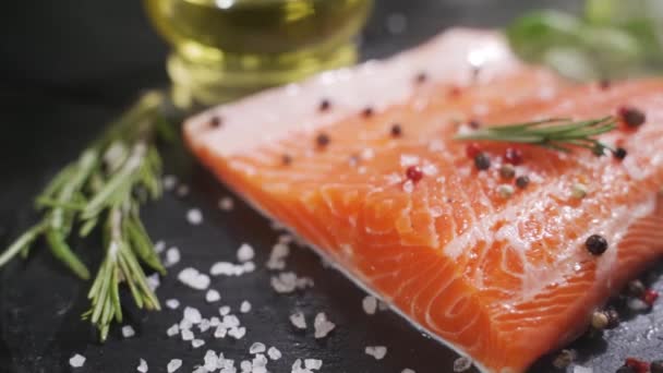 Preparation of salmon steak. Spice and salt sprinkled on a raw piece of salmon. — Stock Video