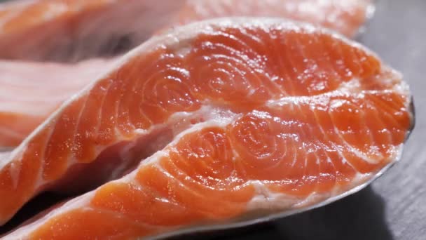 Salmone. Bistecca di pesce rosso di trota cruda ruotata su ardesia. — Video Stock