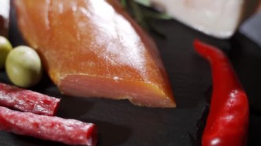 Çeşitli mezeler, jambon, salam, pastırma ve domatesler siyah taş tepside.