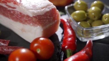 Çeşitli mezeler, jambon, salam, pastırma ve domatesler siyah taş tepside.
