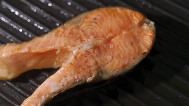 Receta de cocina de pescado. Trozo de filete de salmón o trucha friendo en sartén a la parrilla — Vídeos de Stock