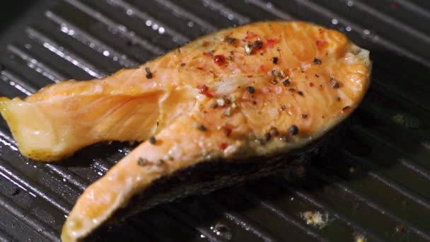 Łosoś na patelni, pstrąg. Kawałki czerwonej ryby smażone na patelni. — Wideo stockowe