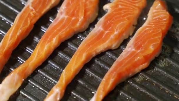 Шматочок філе лосося або форелі смажать на сковороді . — стокове відео