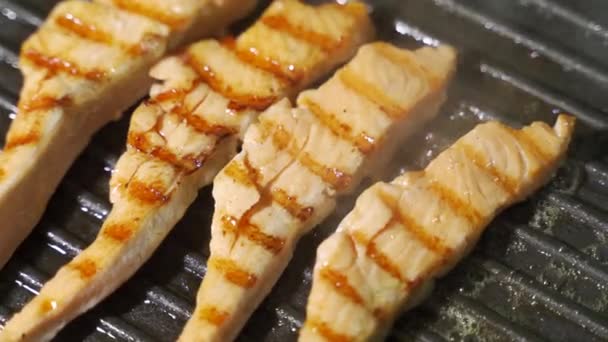 Betina memasak bumbu hitam salmon steak lada di panggangan. — Stok Video