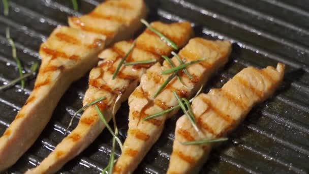 Grilování filet z lososa na grilu venku. Uzavřít filet z lososa na grilu na dřevěném uhlí. — Stock video